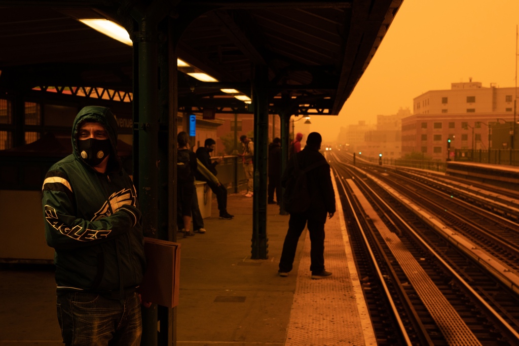 Bronx subway passengers wait for a train in the haze of smoke from the wildfires drifting down from Canada.